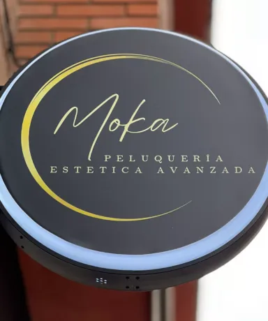 Cartel circular con el texto "Moka Peluquería Estética Avanzada"